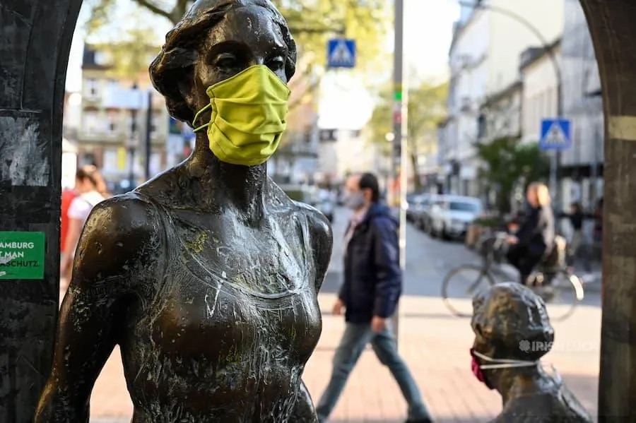 GERMANY, Hamburg, Ottensen, Corona Virus, COVID-19 , Ottenser Torbogen, two women sculpture by artist Doris Waschk-Balz , somebody has put a protective mask to protect them from Covid-19