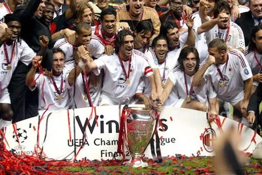 AC Milan players get their hands on the UEFA Champions League trophy as they celebrate their win against Juventus